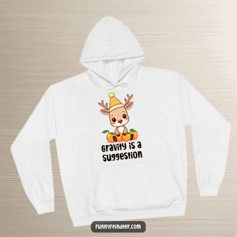 Funny reindeer in a silly hat, comically juggling oranges, featured on a warm and cozy hoodie. Ideal for winter humor.