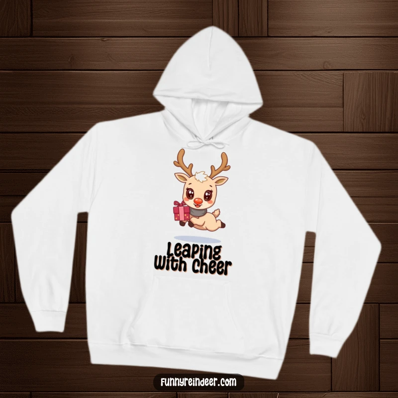 Funny hoodie with a kawaii reindeer, its oversized eyes sparkling, captured in a dynamic leap while holding a large gift package.
